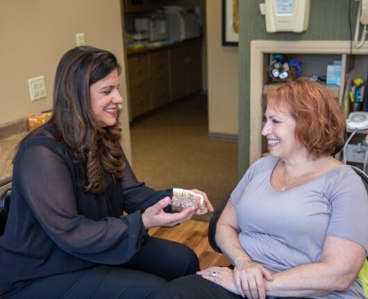 The dentist is showing the Teeth model to the Patient