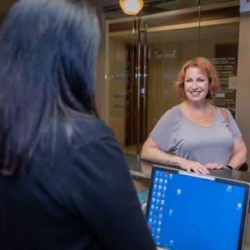 Dental female patient smiling at the reception desk