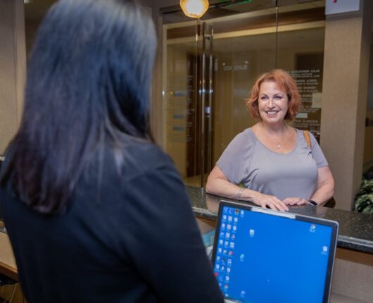 Dental female patient smiling at the reception desk