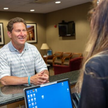 Patient at the reception desk of Great neck dental associates