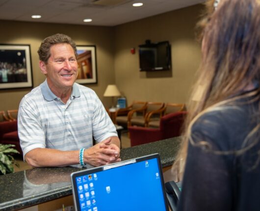 Patient at the reception desk of Great neck dental associates