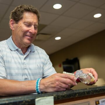 Dental Patient is looking at the tooth model