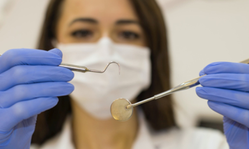 The dentist is following safety precautions before treatment.